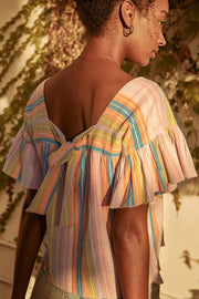 Image of model wearing the SAYLOR Arbor Top in Sherbet, standing outside, back view