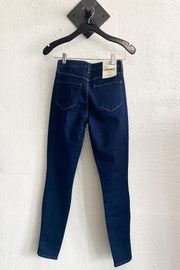 Image of the L'AGENCE Piper H/R Skinny hanging on hanger against white wall, back view