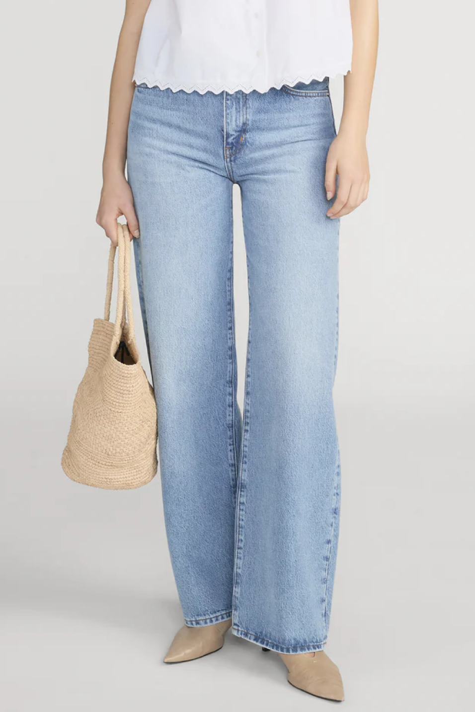 Light blue jeans worn by a person on a plain background