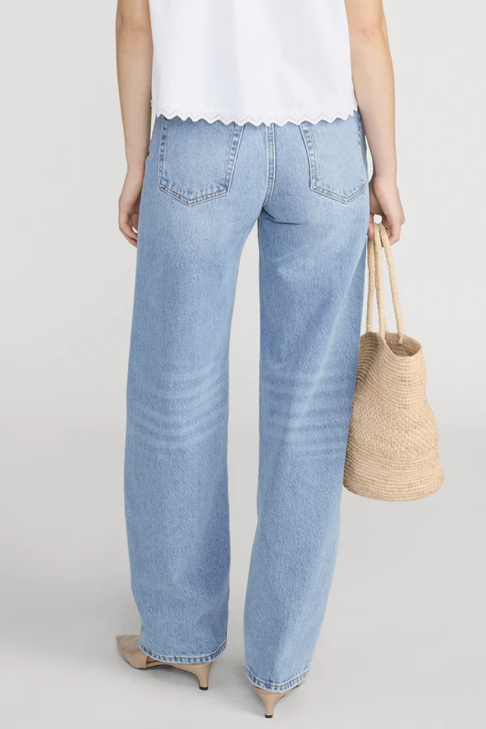 Light blue jeans worn by a person on a plain background