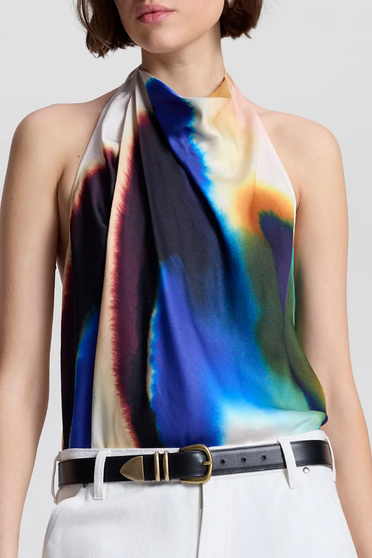 Woman wearing a colorful halter top with a plain background