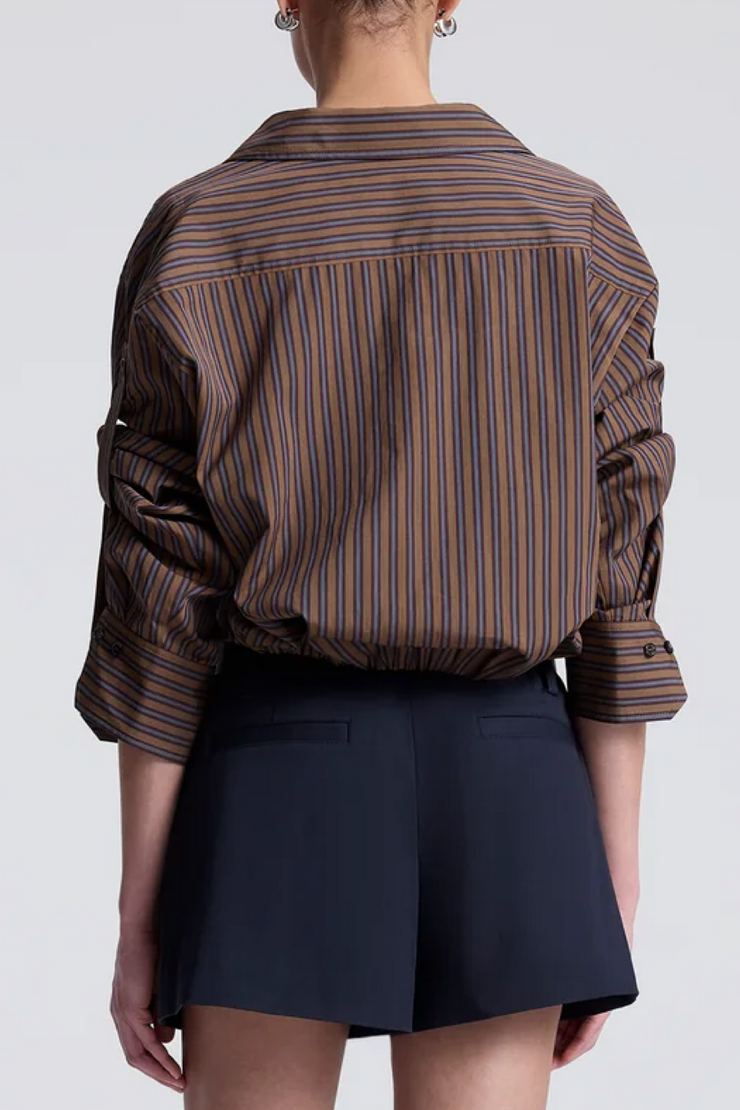 Person wearing a brown striped shirt and navy shorts on a white background