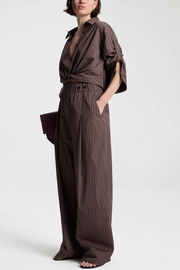 Woman wearing a brown striped outfit on a white background