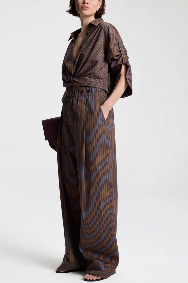 Woman wearing a brown striped outfit on a white background