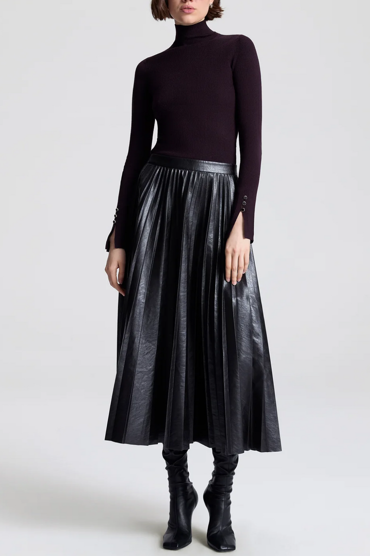 Image of model wearing a vegan pleated leather skirt in deepest brown