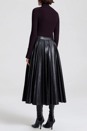 Back image of model wearing a vegan pleated leather skirt in deepest brown