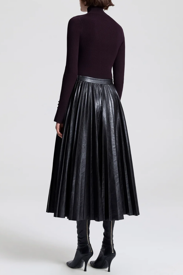 Back image of model wearing a vegan pleated leather skirt in deepest brown