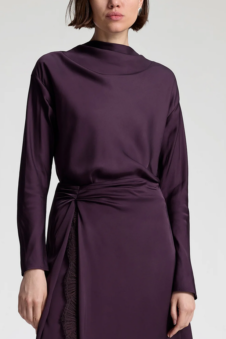 Purple long-sleeve top with a tie waist skirt on a white background