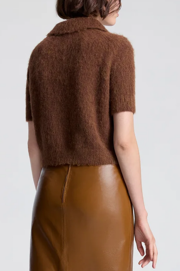 Brown knitted top worn by a person on a white background