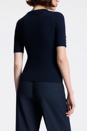 Person wearing a Navy top and dark pants on a white background