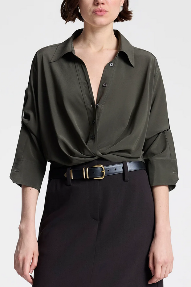 Person wearing a olive brown button-up shirt and black pants on a white background