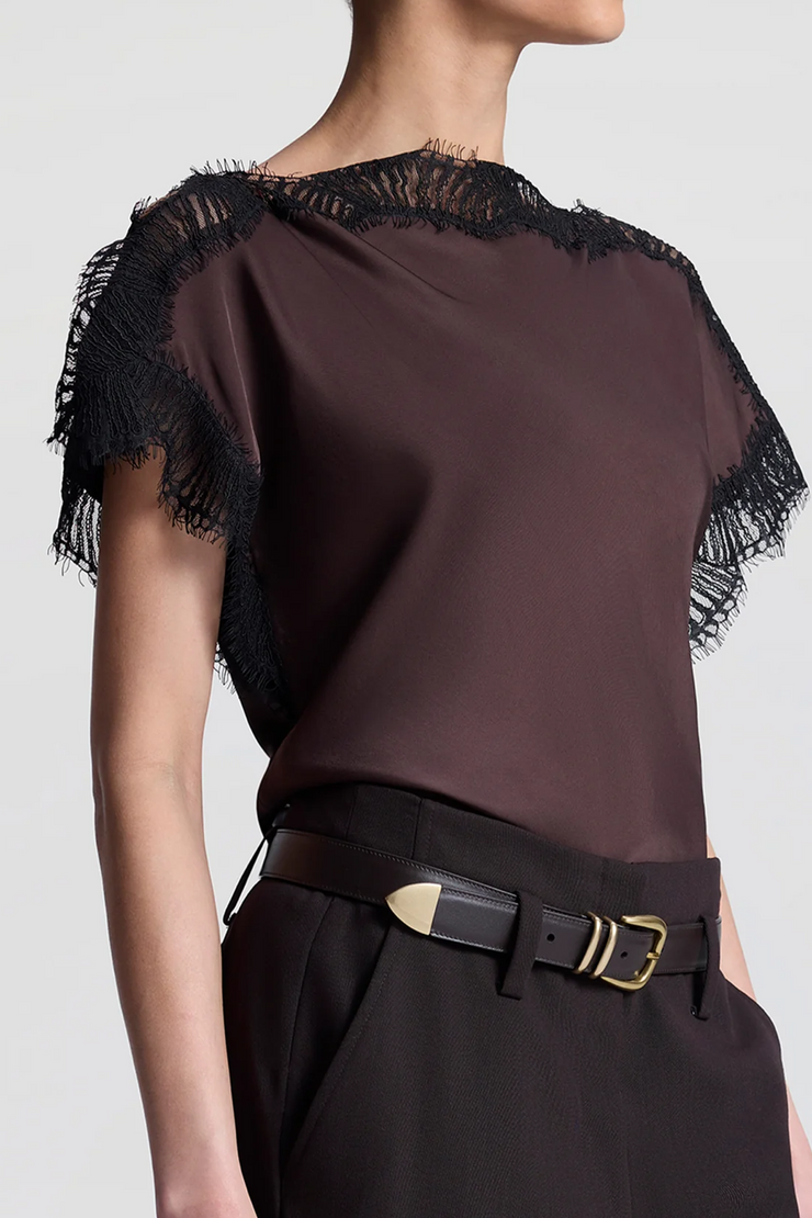 Brown top with black lace details and a belt on a plain background
