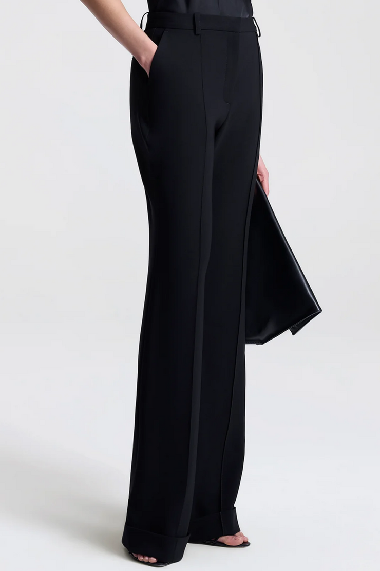 Black pants worn by a person on a white background