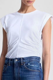 White sleeveless top and blue jeans on a plain background