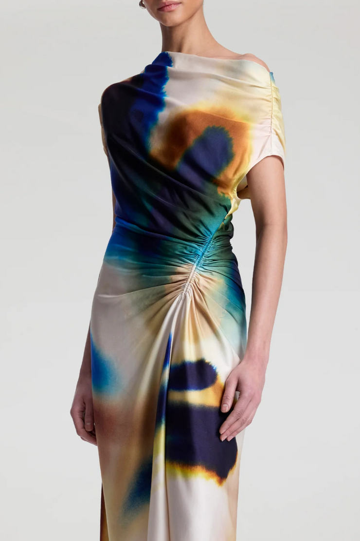 Woman wearing a colorful tie-dye dress on a plain background