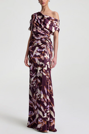 Woman wearing a one-shoulder patterned dress on a white background