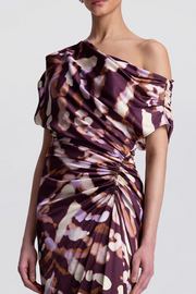 One-shoulder patterned dress on a plain background