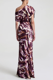 Woman wearing a one-shoulder patterned dress on a white background