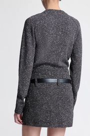 Back view of a person wearing a textured top/skirt with a belt on a white background