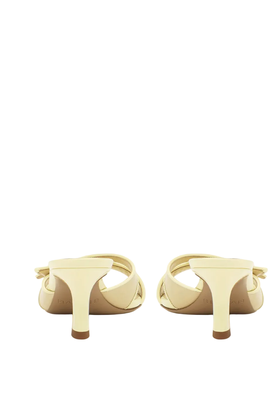 Pair of creamy yellow heeled shoes on a white background