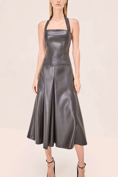 Black leather dress worn by a model on a beige background
