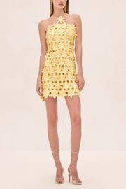 Yellow floral dress worn by a model on a beige background