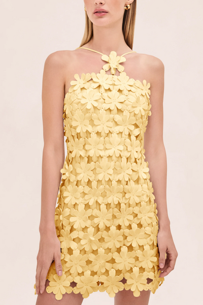 Yellow floral dress on a model against a light pink background