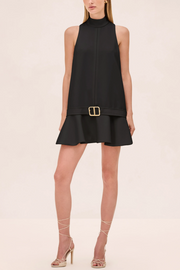 Black sleeveless dress with a belt on a beige background
