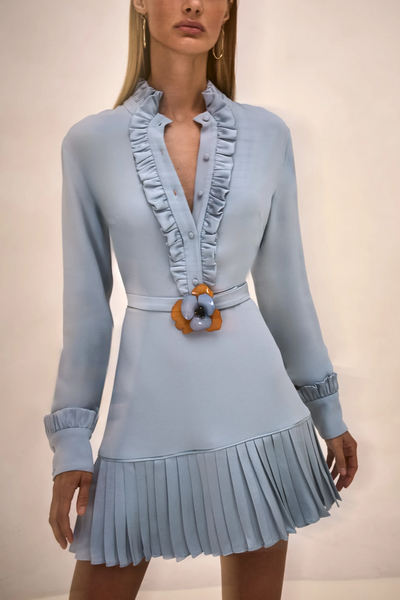 Light blue dress with ruffled collar and pleated skirt on a neutral background