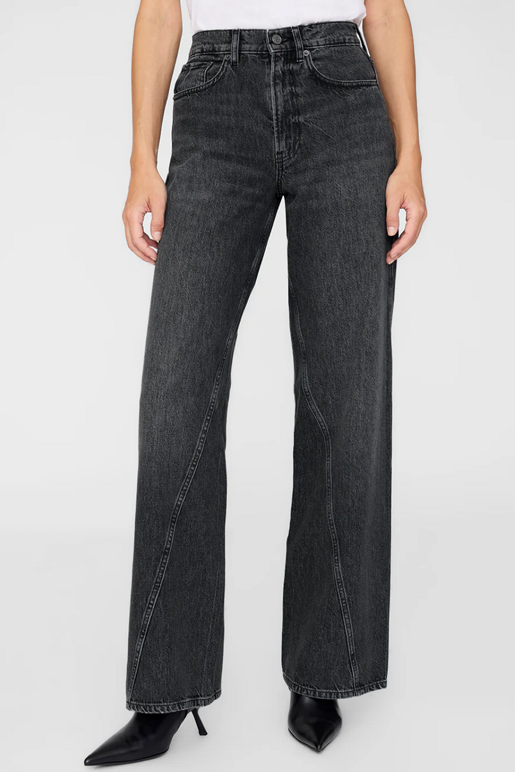 Black jeans worn by a person on a white background