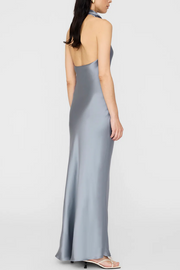 Woman wearing a long, light blue satin dress on a white background