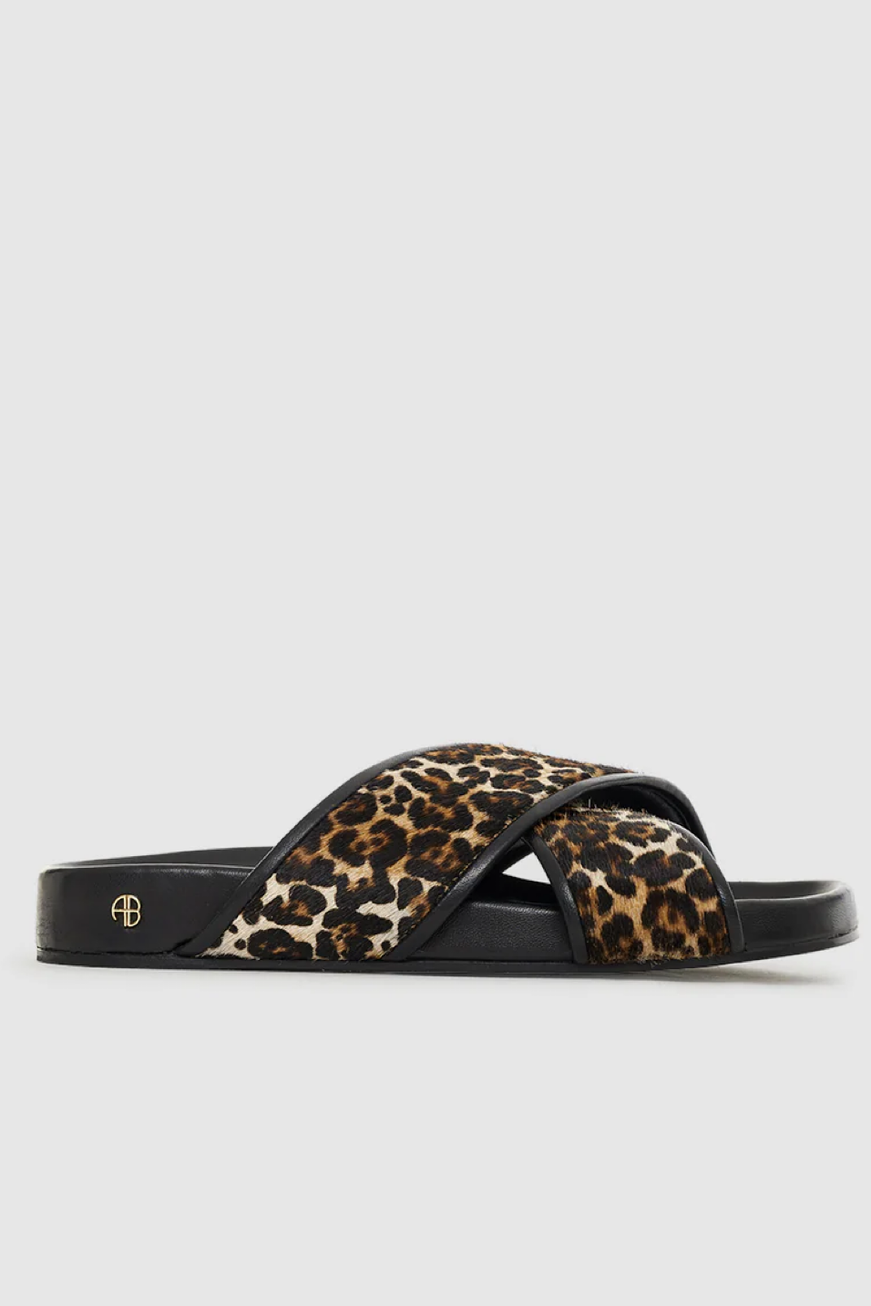 Leopard print sandal with black straps on a light gray background