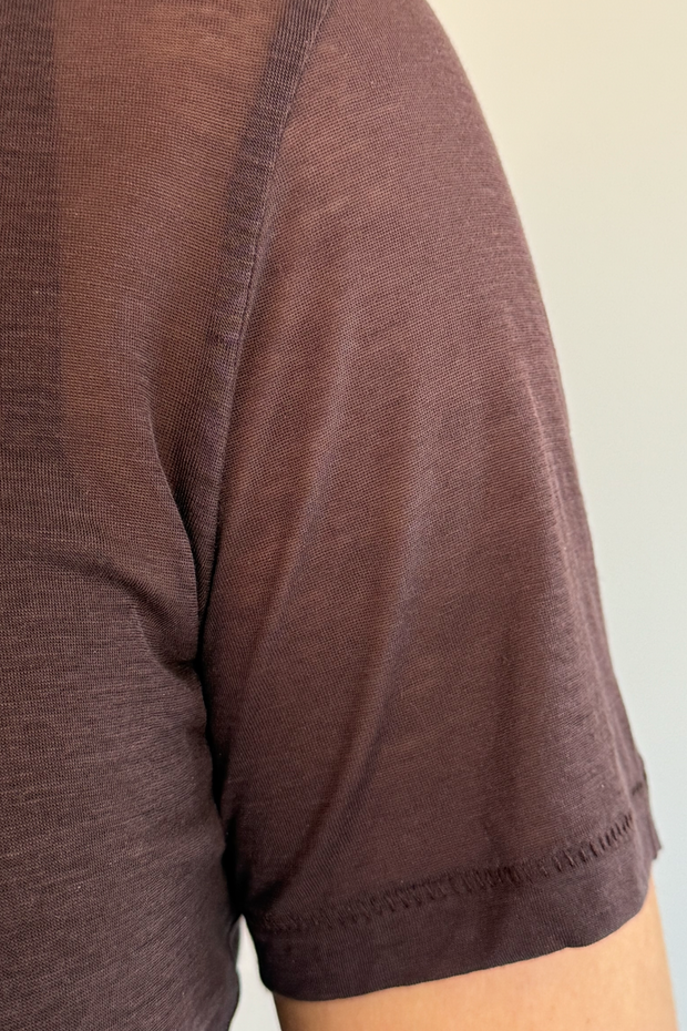 Close-up of a brown shirt sleeve on a plain background