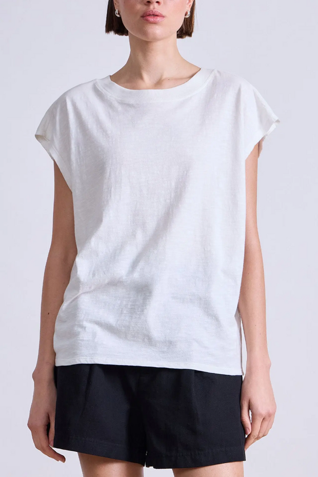 Person wearing a white sleeveless top and black shorts on a plain background