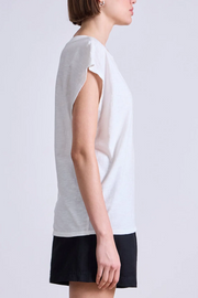 Woman wearing a white sleeveless top and black skirt on a light gray background