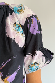 Close-up of a floral top with colorful flowers on a plain background