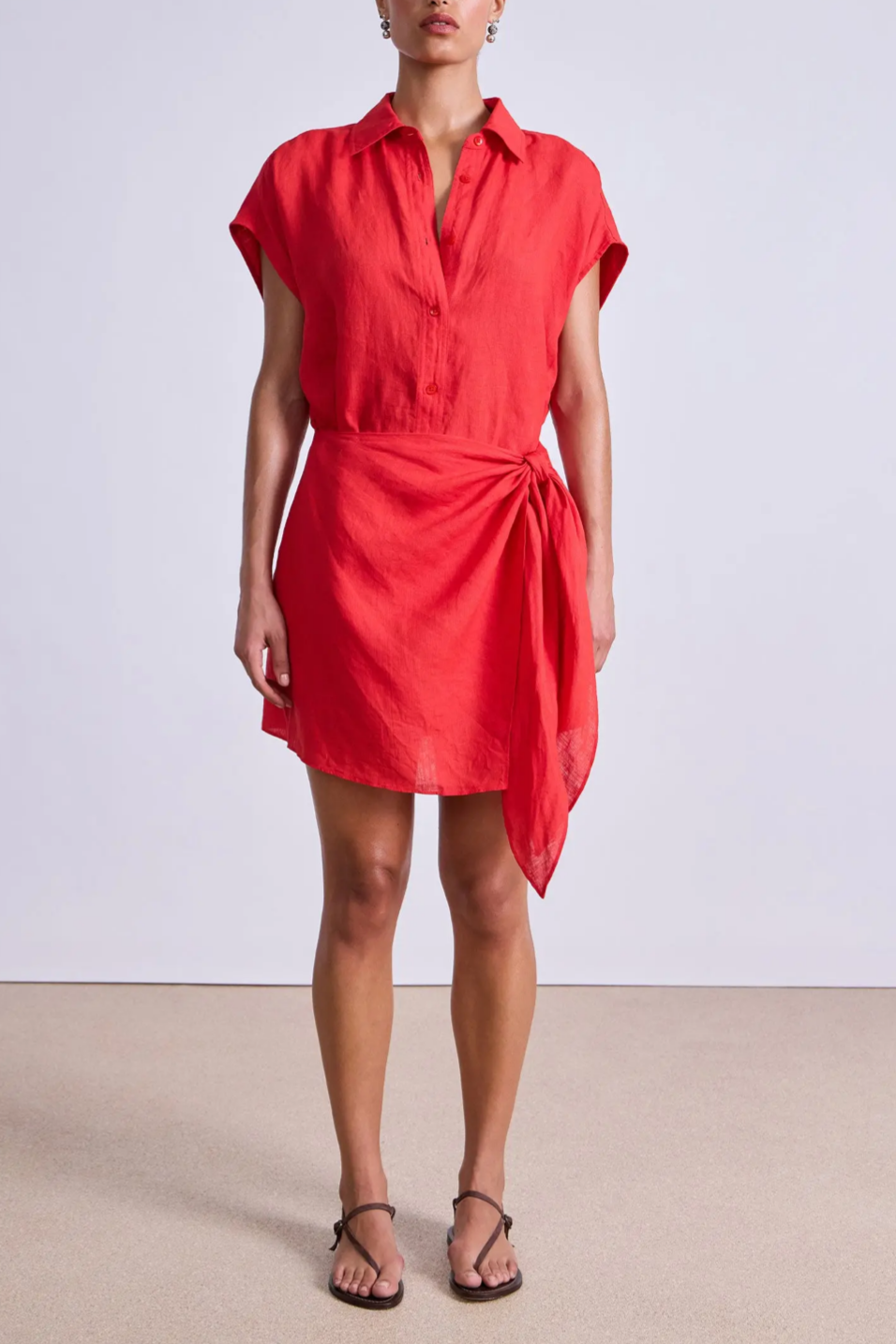 Red dress worn by a person on a plain background