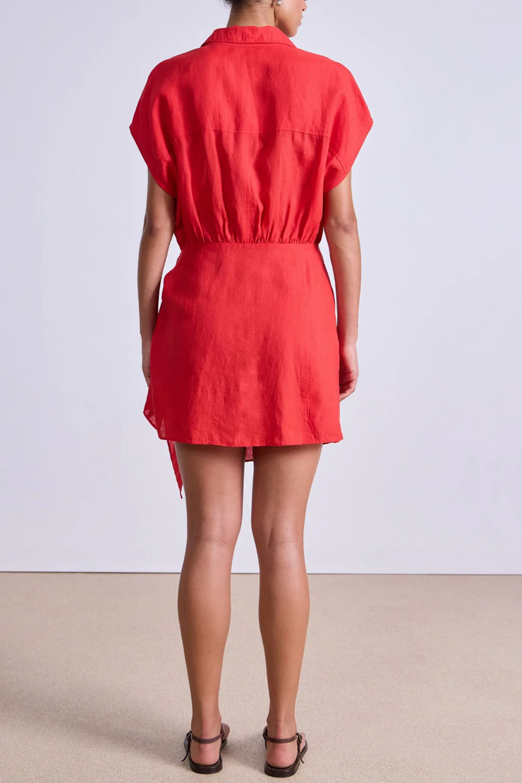 Person wearing a red dress against a plain background