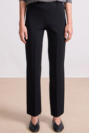 Person wearing black pants on a plain background