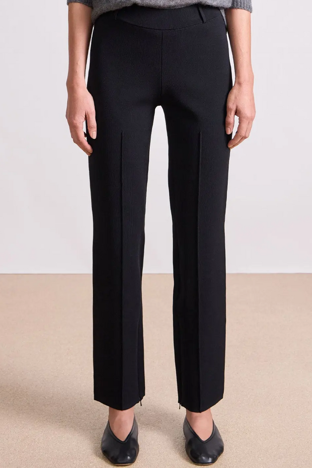 Person wearing black pants on a plain background