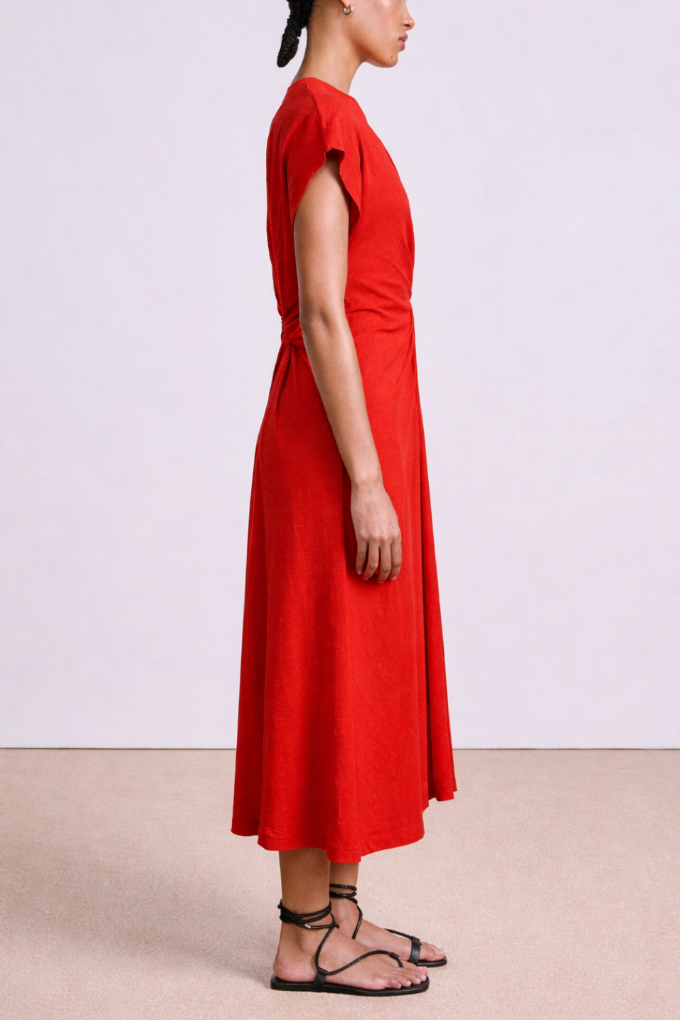 Person wearing a red dress on a plain background