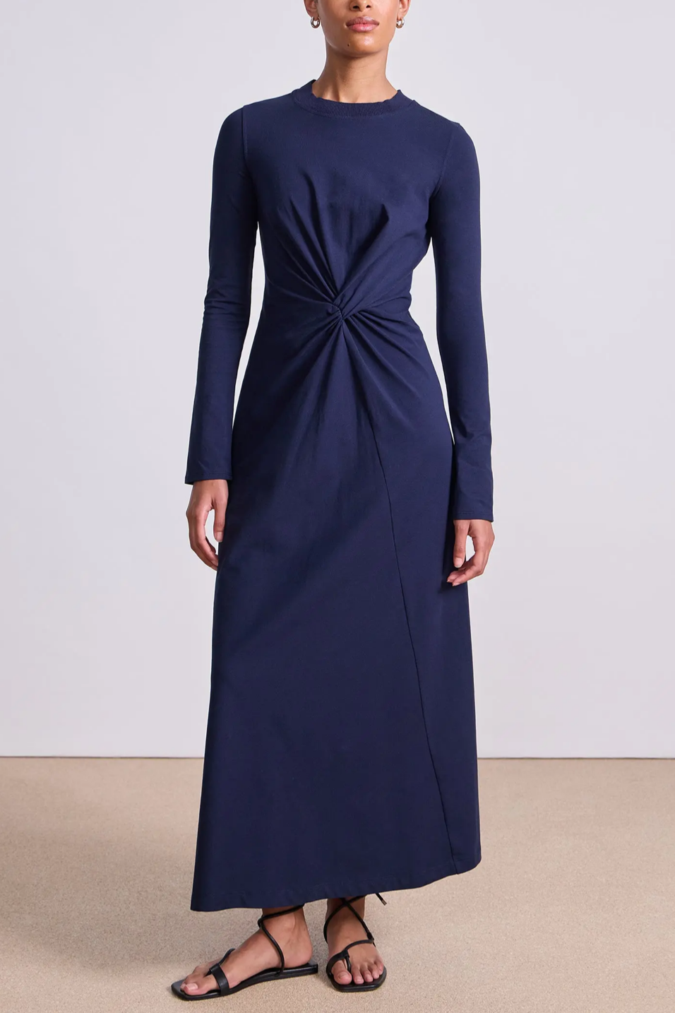 Navy blue long-sleeve dress with a knot detail on a plain background