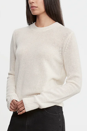 Woman wearing a white sweater on a plain background