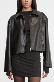Person wearing a black leather jacket over a black outfit on a white background