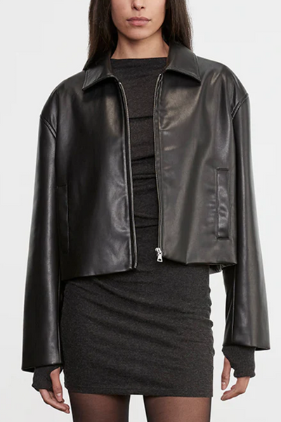 Person wearing a black leather jacket over a black outfit on a white background