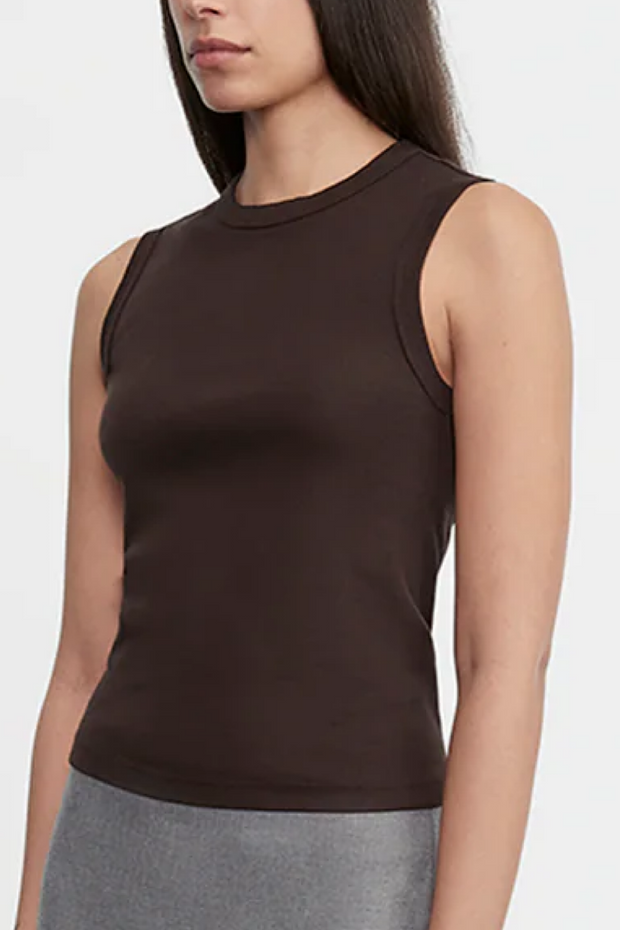 Woman wearing a brown sleeveless top against a white background