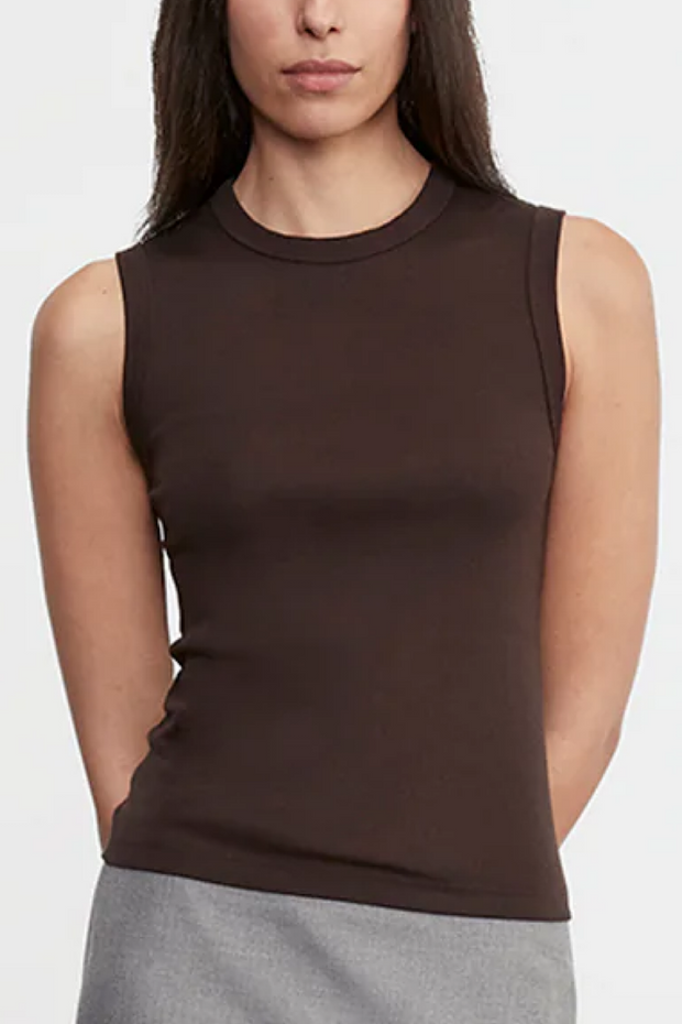 Woman wearing a brown sleeveless top against a white background