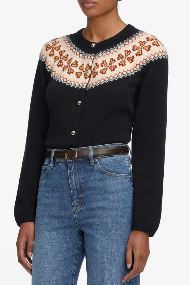 Person wearing a navy blue fairisle cardigan and blue jeans