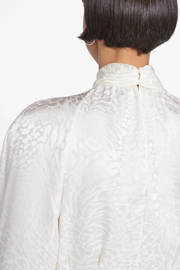 Image of model wearing Frame foldover mock neck blouse in off white