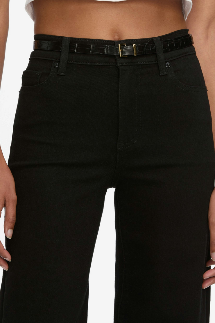 Black jeans worn by a person on a white background